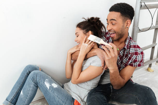 istock Smiling young loving couple sitting on floor in new flat 1355521193