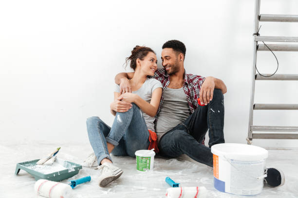 istock Cheerful multiethnic young couple renovating home and resting 1355521523