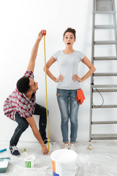 istock Man and woman using measure tape 1355522450