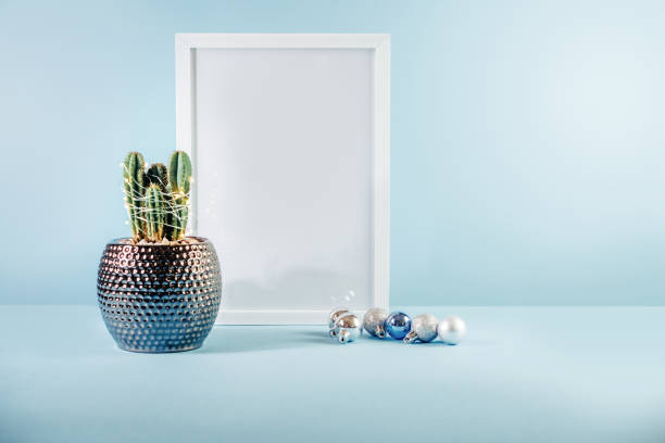 istock Christmas mock-up with white frame, cactus and Christmas balls on blue background 1355522582