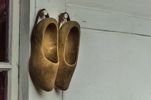 pair of Dutch wooden shoes hanging next to a door