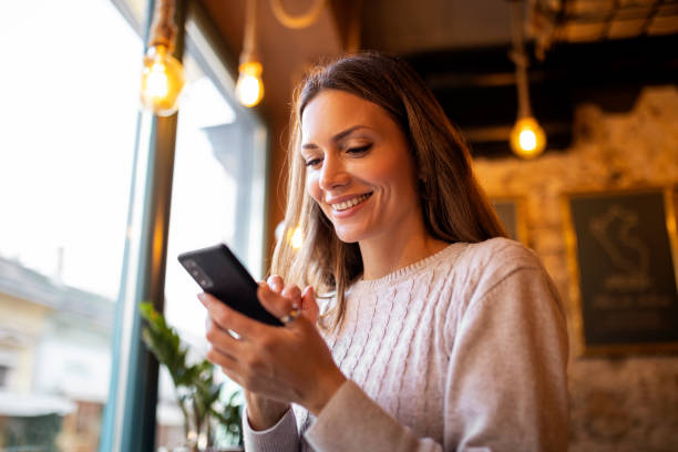 istock Young  woman drinking coffee and using mobile phone for texting 1355523537