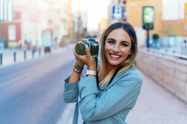 istock Positive photographer with retro camera in city 1355524340