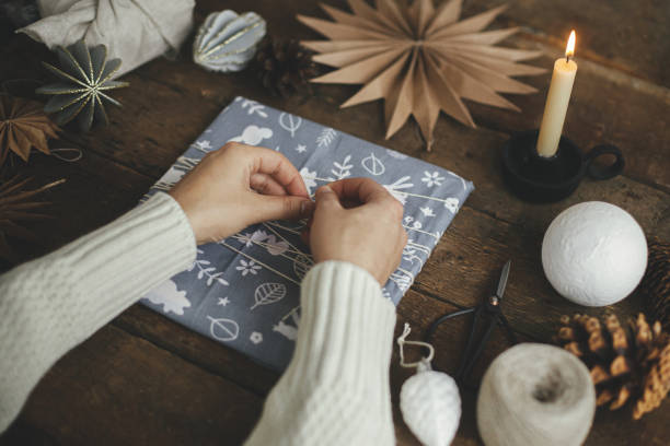 istock Zero waste christmas gift. Hands wrapping christmas gift in fabric on rustic table. Happy Holidays! 1355524947