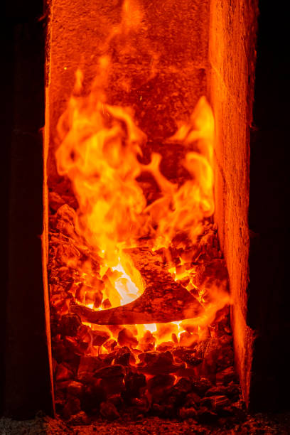 istock A red-hot ax on coals in a forge. Flame in the forge of the blacksmith. 1355525063