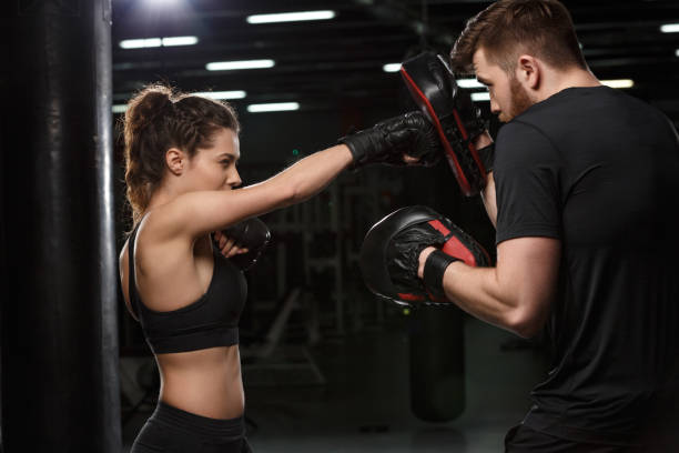istock Concentrated young strong sports lady boxer make exercises 1355525935