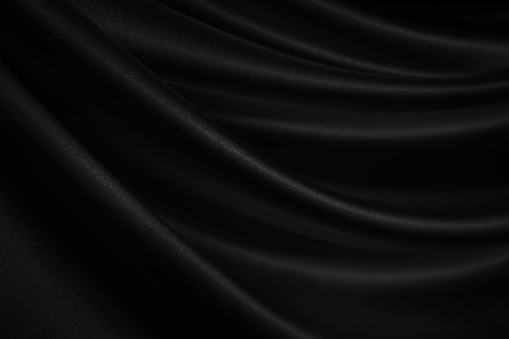 Black silk satin. Soft, wavy folds. Fabric surface. Luxurious black white background with copy space for design. Web banner.
