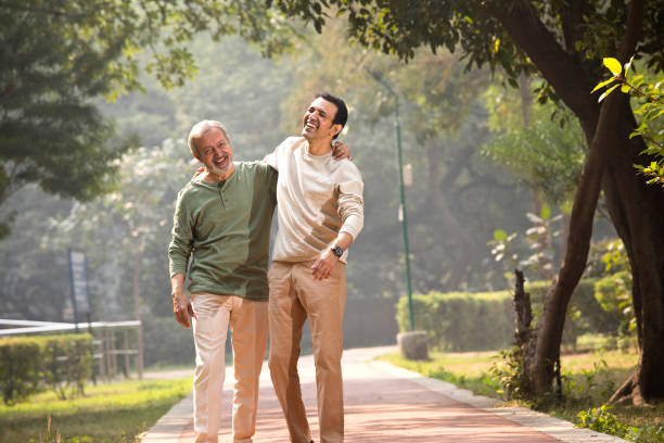 istock Happy senior man walking with son at park 1355527182