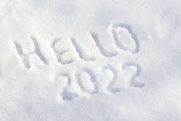 istock Snow surface and text Hello 2022. Inscription draw on white snow 1355527293