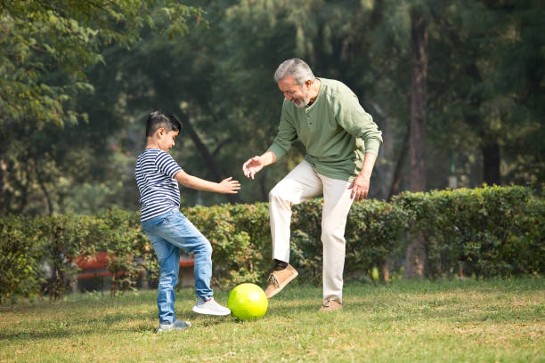 istock Senior man playing with grandson at park 1355527418