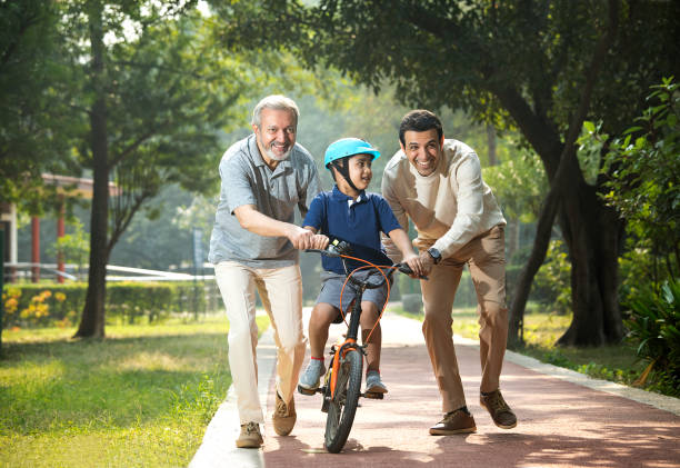 istock Boy learning bicycle with father and grandfather at park 1355528887