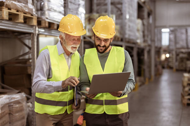istock Senior manager and male worker using Laptop in a Distribution Warehouse 1355530172