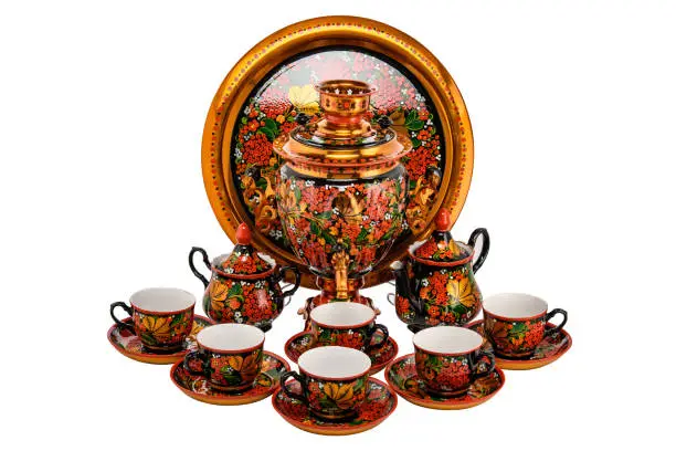 Tea Set of Old Traditional Russian folk utensils and Samovar. Dishes with handmade painting floral ornament in style of Khokhloma isolated on white background.