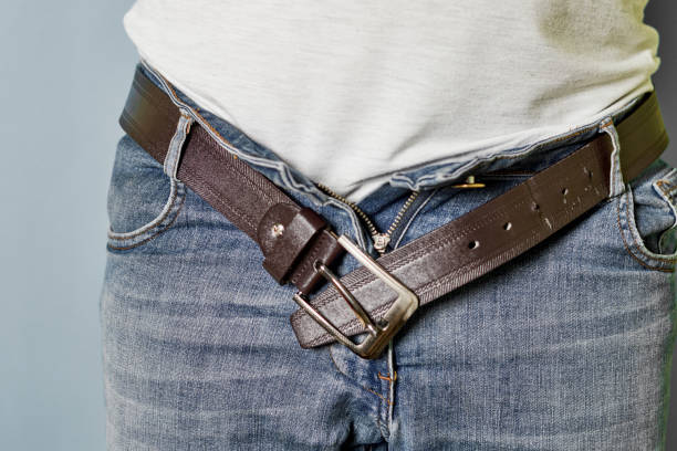 A man with unbuckled belt stock photo