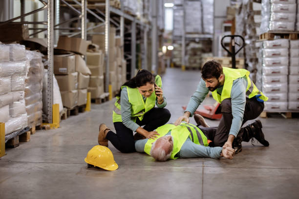 istock Worker Call an Ambulance While Senior Warehouse Manager Lying Down on Warehouse 1355532498