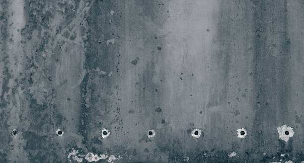 istock Grunge stone background with bullet holes 1355534328