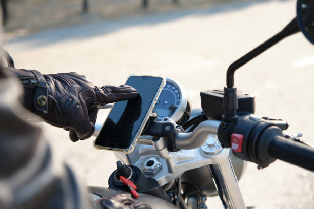 Close up of a person using mobile phone on motorbike stock photo