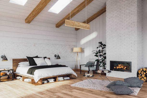 Scandinavian Bedroom In A Luxurious Cottage House Interior of a Scandinavian style attic bedroom with fireplace in a cottage house. bedroom stock pictures, royalty-free photos & images