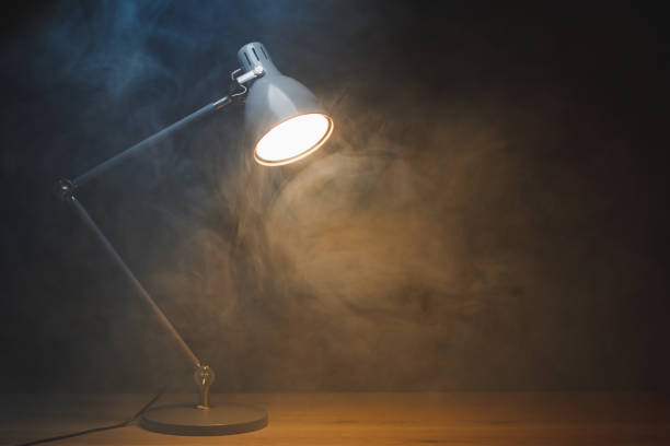 istock desk lamp in smoke, copy-space background 1355537703