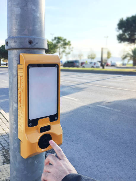 istock Finger pushing stoplight push button at the roadside. Traffic light control box 1355537845