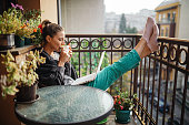 Young woman using laptop on balcony at morning