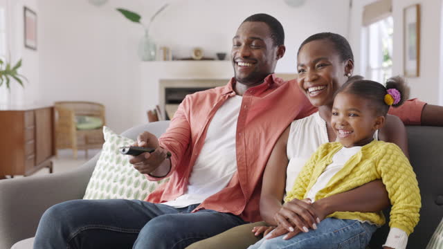 Happy african american family watching TV at home