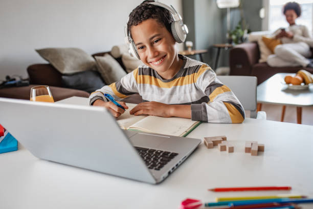 istock Teenage boy at home, learning with the laptop 1355543555