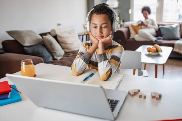 istock Teenage boy at home, learning with the laptop 1355543597