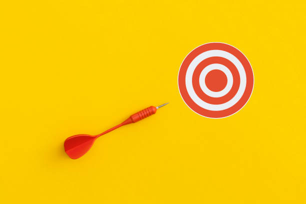 istock Dart and red target on a yellow background. Top view. Flat lay. 1355543788