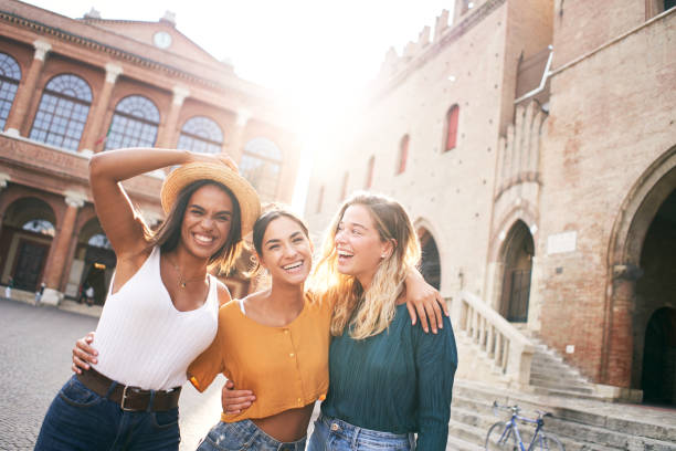 скопируйте космический портрет трех женщин, смотрящих в камеру. девушки стоят на площади туристического города. - italian culture women looking at camera cheerful стоковые фото и изображения