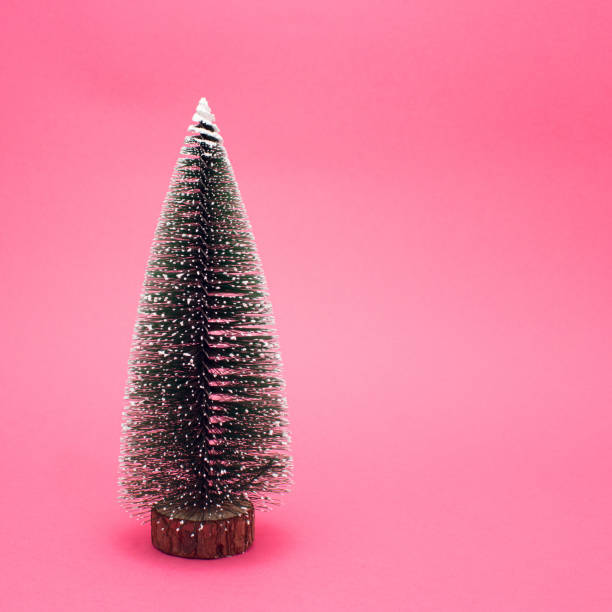 istock Christmas tree on bright pink background. Minimal New Year concept. Vibrant winter. 1355552117