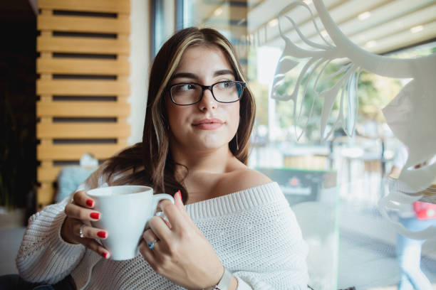 istock A smiling calm young woman spends time in a cafe 1355552473