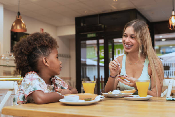 istock Interracial mother and daughter have a happy breakfast in a restaurant 1355561649