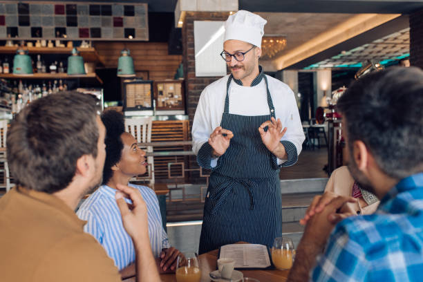 istock Chef at the restaurant advising guests what to order 1355563843