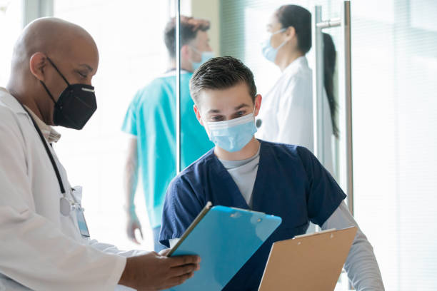 istock Surgeon and nurse reading patient chart 1355563994