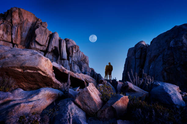 couple in love huge each other on the rock watching the night sky with Moon over the mountains couple in love huge each other on the rock watching the night sky with Moon over the mountains chile tourist stock pictures, royalty-free photos & images