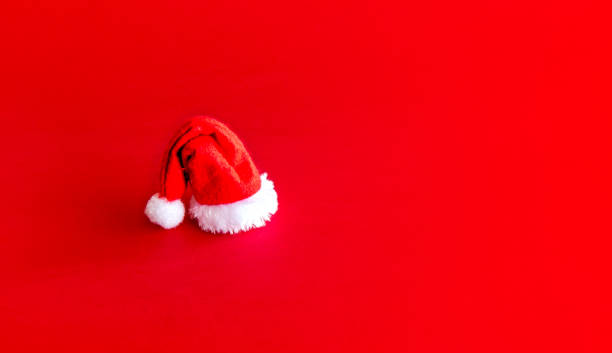 istock Christmas decoration. Mini Christmas cap on red background 1355567254