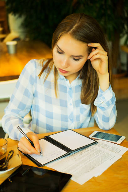 istock smart woman writing down her ideas and drinking coffe in cafe 1355577434