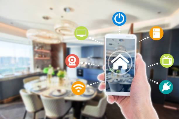 istock Smart home automation app on mobile with home interior in background. Internet of things concept at home. 1355578278