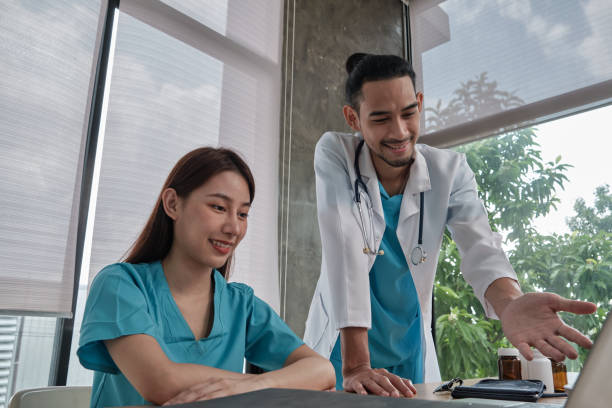 istock Two uniformed young doctors work in medical clinic office. 1355579995