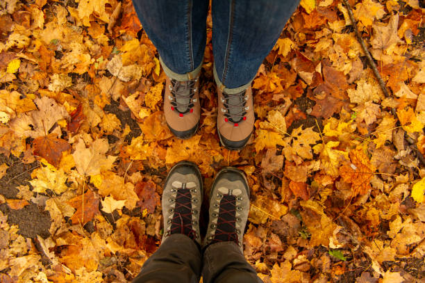 Couple Man and Woman Feet Autumn leaves on background stock photo