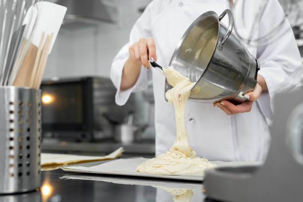 istock Pastry chef pours the biscuit on the baking parchment. 1355597195