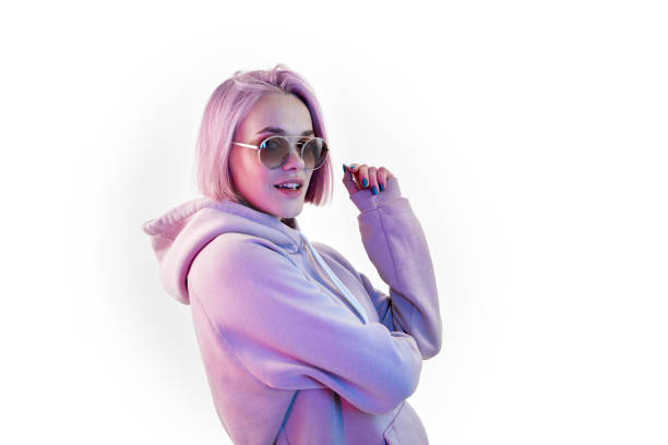 Woman with pink hair in sunglasses on white background stock photo