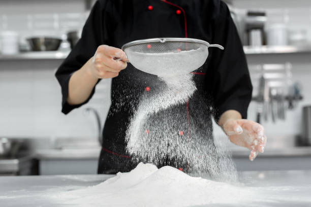 istock The pastry chef's hands sift the flour through a sieve on the table. 1355597404