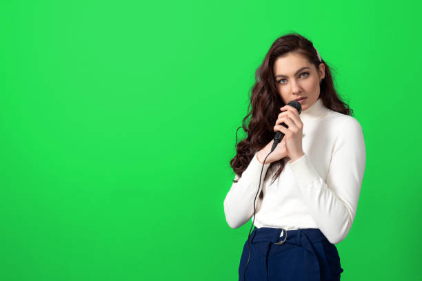 istock attractive female conference speaker during presentation, holds microphone and makes some gestures 1355600249