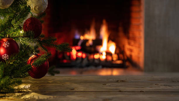 istock Christmas tree and burning fireplace background. Wooden table desk empty, template 1355602754