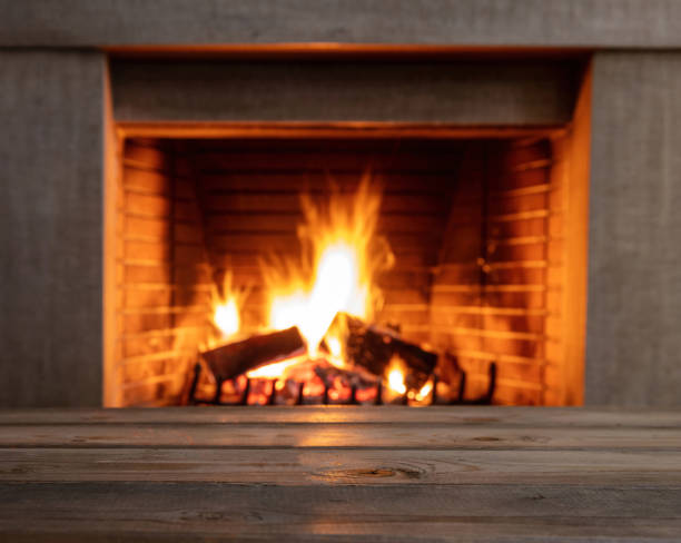 istock Table on blur burning fireplace background. Empty wooden planks, space. 1355602768