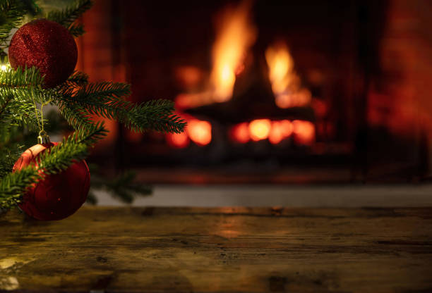 istock Christmas tree and burning fireplace background. Wooden table desk empty, template 1355602805