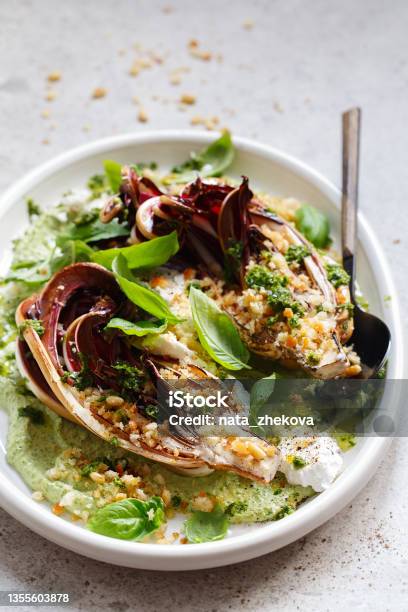 Roasted Radicchio Salad With Feta Green Tahini Pine Nuts And Basil Pesto Radicchio Rosso Di Treviso Tardivo Italian Red Chicory Healthy Meal Recipe Preparation Plantbased Dishes Green Living Stock Photo - Download Image Now