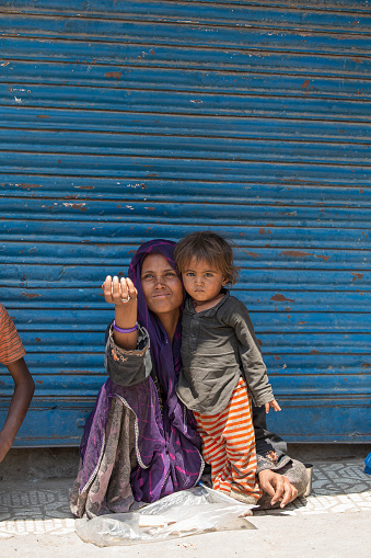 Srinagar, India - july 03, 2015 : Poor Indian beggar woman ahd child on the street market in Srinagar, Jammu and Kashmir state, India. In India, young children are often recruited into begging